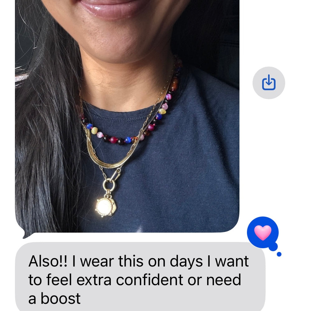 Woman wearing a colorful beaded amber and gemstones necklace layered with gold jewelry, text overlay about confidence and boost